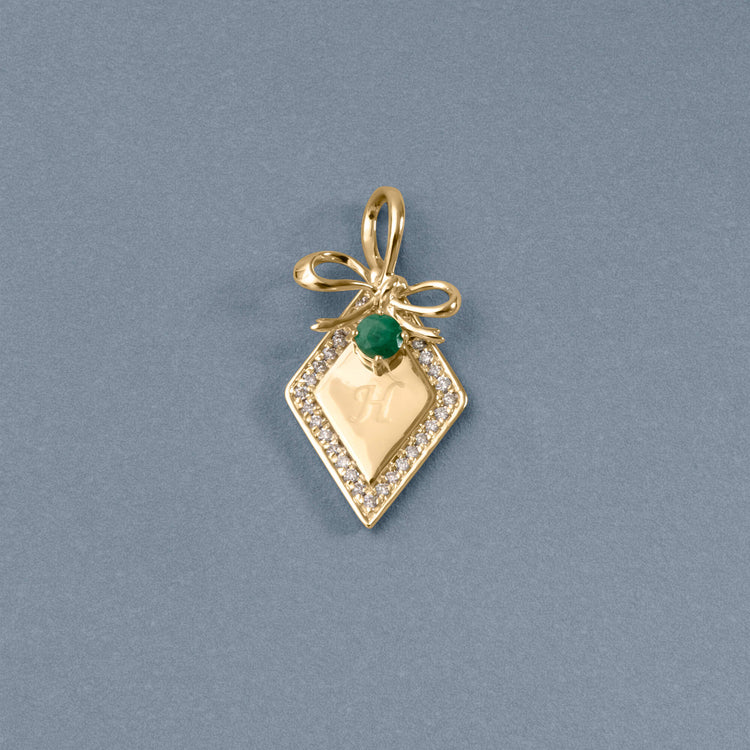 Stone and Strand 10K Yellow Gold Bow Nouveau Diamond and Emerald Tag Charm Editorial Image