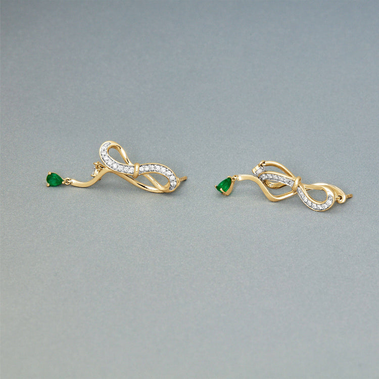 Stone and Strand 14K Yellow Gold Bow Nouveau Diamond and Emerald Gala Earrings Editorial Image