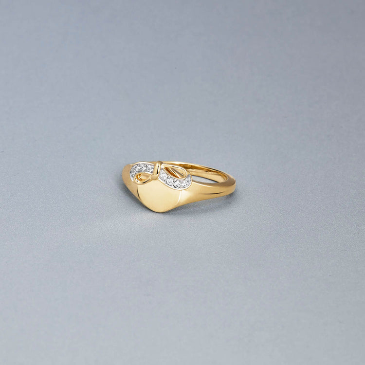 Stone and Strand 10K Yellow Gold Bow Nouveau Diamond Signet Ring Editorial Image