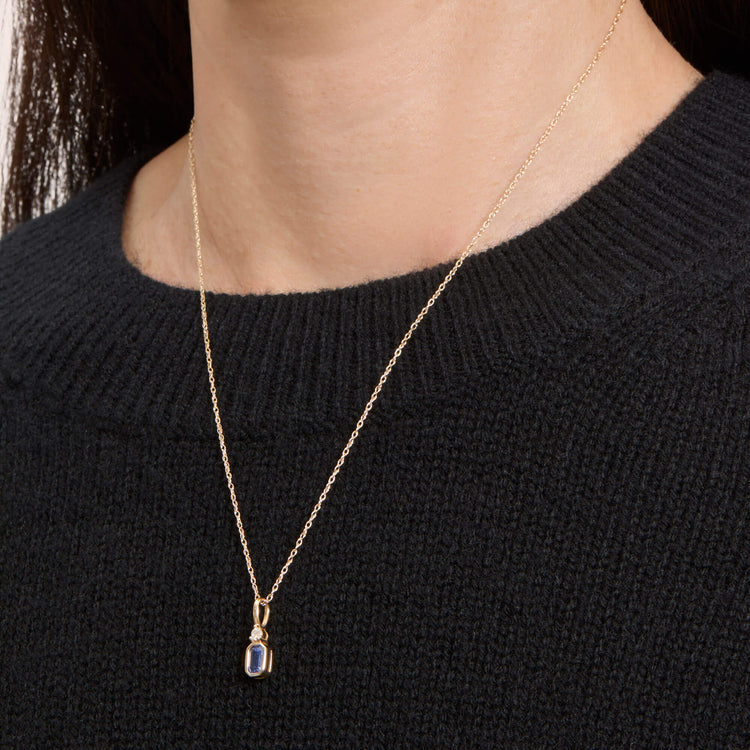 Image of 10K Yellow Gold Corona X Diamond Necklace with Tanzanite on Models Neck