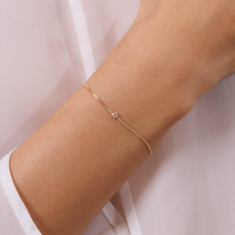 Image of 14K Yellow Gold Dainty Bezel Solitaire Curb Chain Bracelet on Models Arm