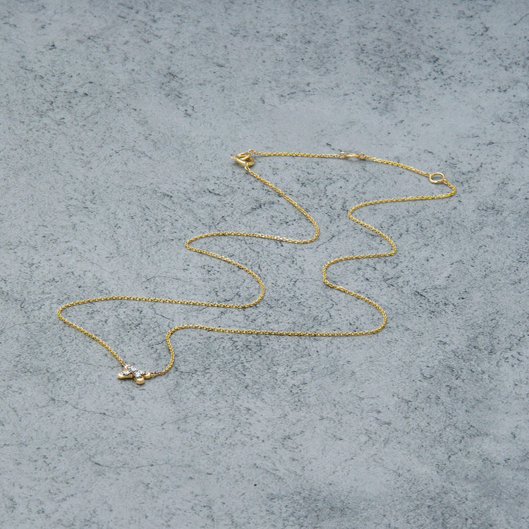 Stone and Strand 14K Yellow Gold Diamond Cross Stitch Necklace Editorial Image