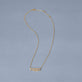 Stone and Strand 14K Yellow Gold Diamond Gothic Name Necklace Editorial Image