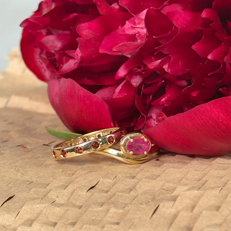 Still life image of Fauvist Form Garnet Ring with Stone and Strand solid gold jewelry
