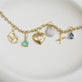 Still life image of The Salt To My Pretzel Charm with Stone and Strand solid gold jewelry