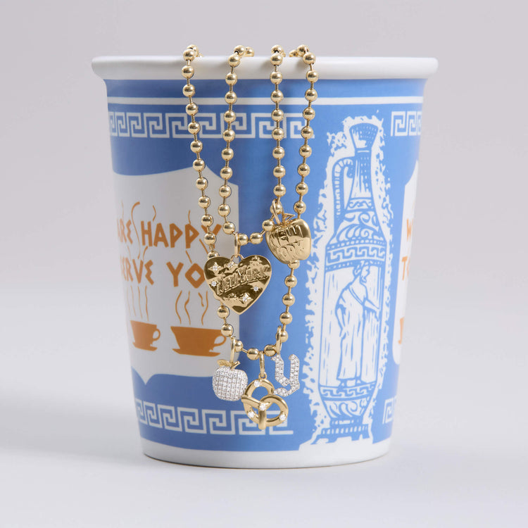 Still life image of The Big Pave Apple Charm with Stone and Strand solid gold jewelry