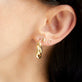Model wearing Small Gold Puff Heart Stud Earrings with solid gold Stone and Strand jewelry