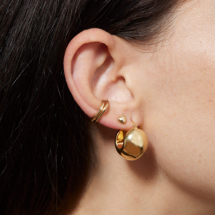 Model wearing Ultra Puff Gold Huggies with solid gold Stone and Strand jewelry