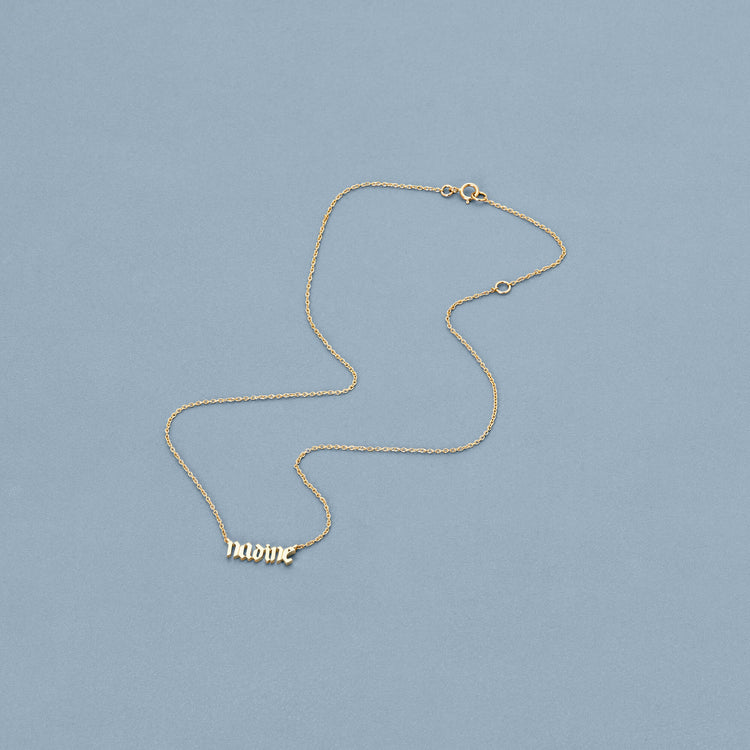 Stone and Strand 14K Yellow Gold Gold Gothic Nameplate Choker Editorial Image