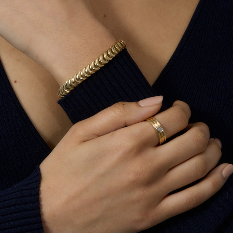 Model wearing Gold La Scala Bracelet with solid gold Stone and Strand jewelry