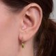 Image of 14K Yellow Gold Green Tourmaline Knife Edge Shield Drop Huggies on Models Ear