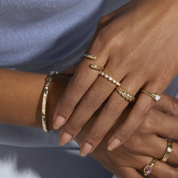 Model wearing Golden Droplet Hug Ring with solid gold Stone and Strand jewelry