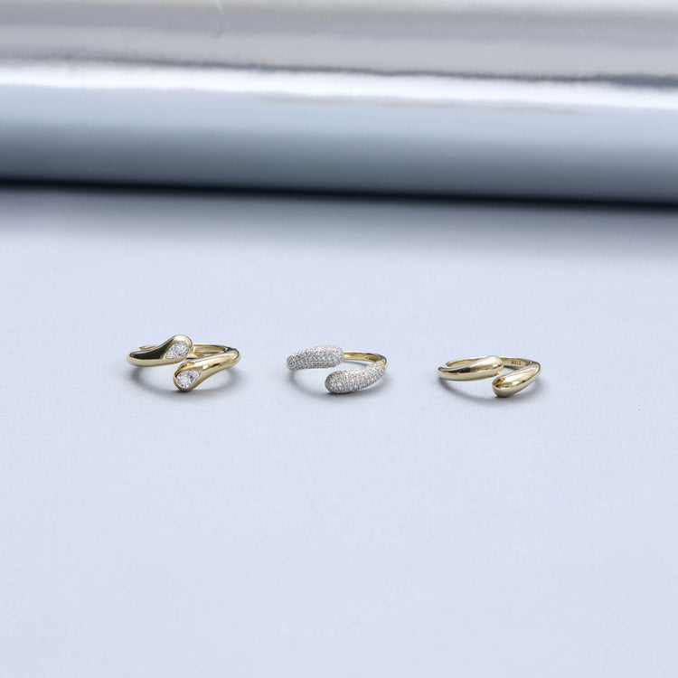 Still life image of Golden Droplet Hug Ring with Stone and Strand solid gold jewelry