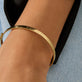 Image of 14K Yellow Gold Je Ne Regrette Gold Bangle on Models Arm
