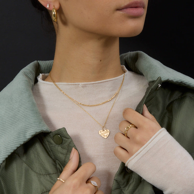 Model wearing Gold Doughnut Hoops with solid gold Stone and Strand jewelry
