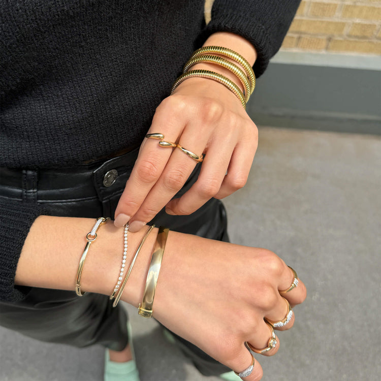 Model wearing Gold Cigar Bangle with solid gold Stone and Strand jewelry