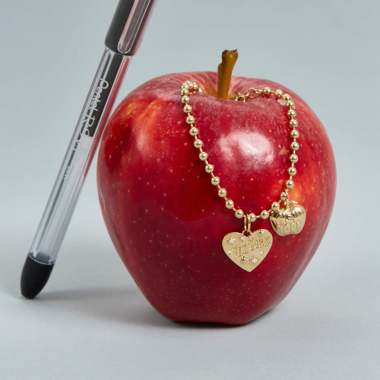 Still life image of The Big Apple Charm with Stone and Strand solid gold jewelry