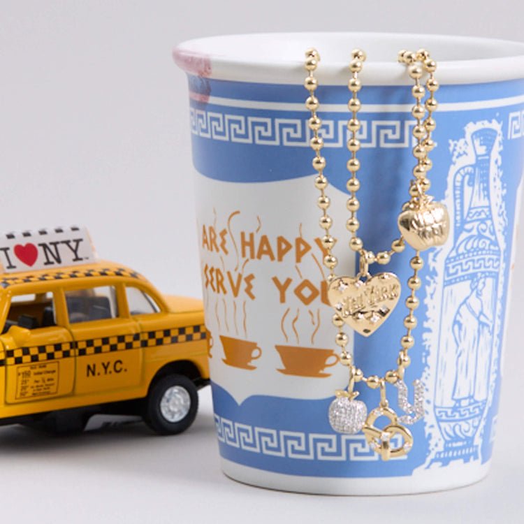 Still life image of The Big Apple Charm with Stone and Strand solid gold jewelry