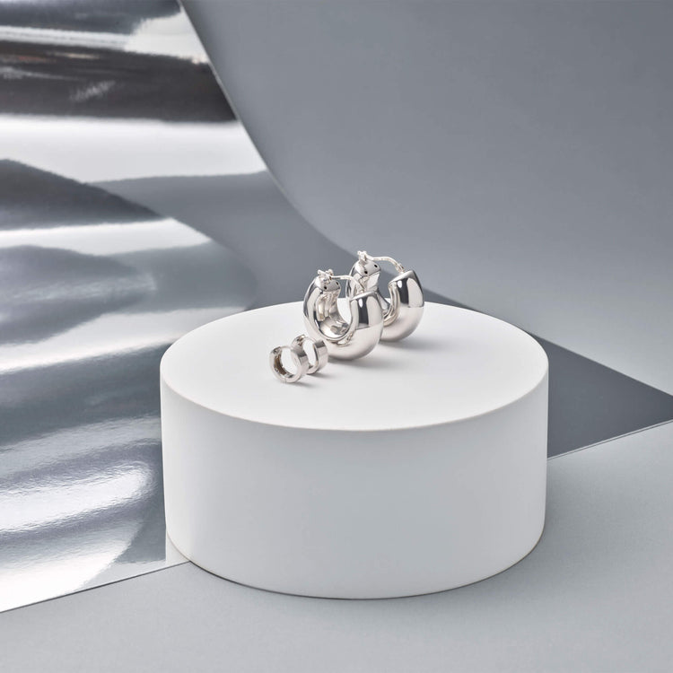 Still life image of Bold Silver Second Hole Huggies with Stone and Strand solid gold jewelry