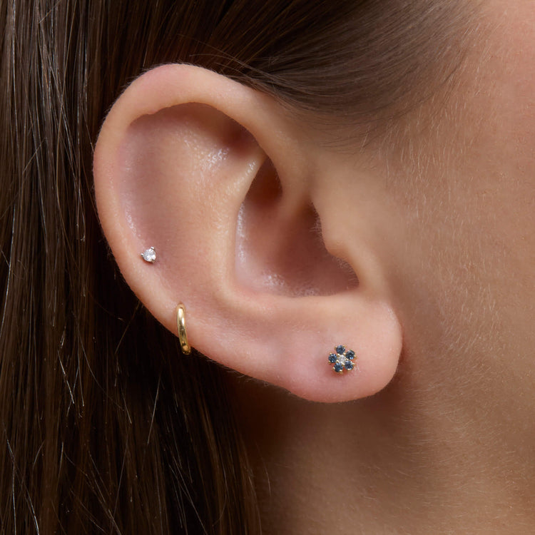 Image of 10K Yellow Gold Small Blue Sapphire and Diamond Flower Stud on Models Ear