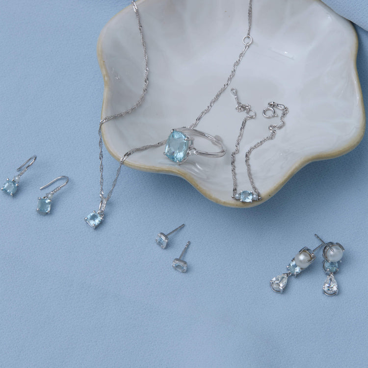 Still life image of Cushion Cut Aquamarine and Pearl Drop Earrings with Stone and Strand solid gold jewelry
