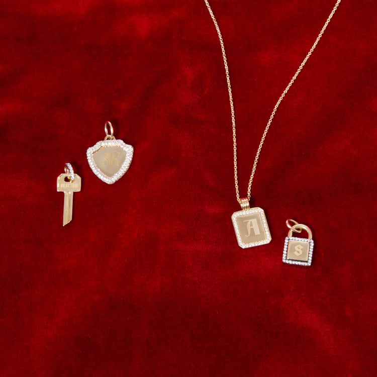 Still life image of Founding Member Diamond Crest Charm with Stone and Strand solid gold jewelry