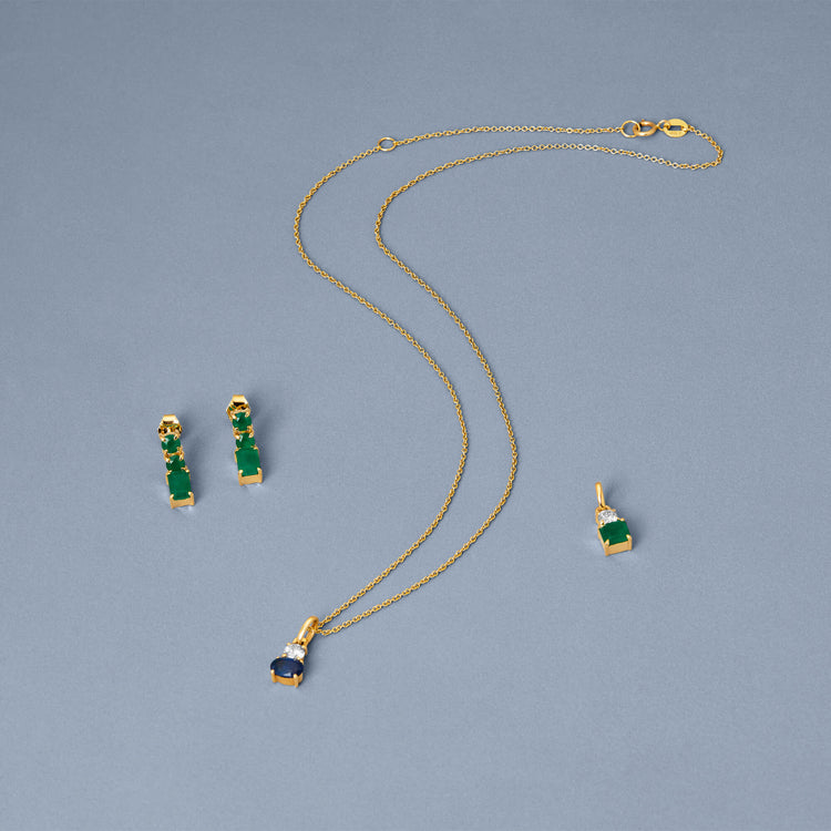 Still life image of Full Volume Emerald Drop Earrings with Stone and Strand solid gold jewelry