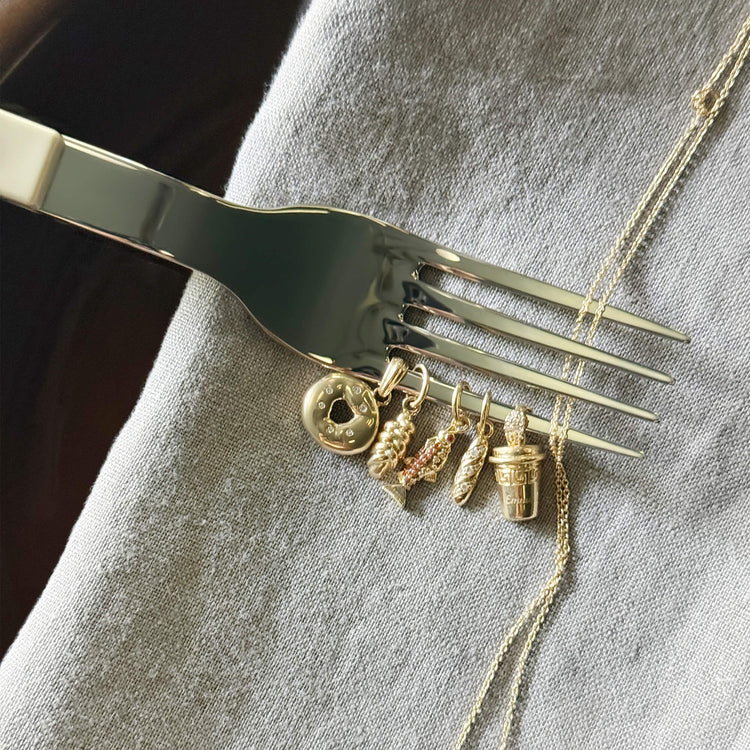 Still life image of Gold Bagel Brunch Charm with Stone and Strand solid gold jewelry