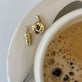 Still life image of Gold Coffee Brunch Charm with Stone and Strand solid gold jewelry