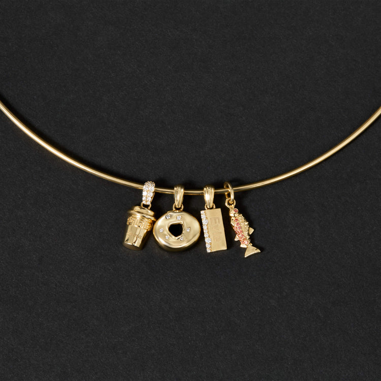 Still life image of Gold Salmon Charm with Stone and Strand solid gold jewelry