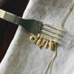 Still life image of Gold Salmon Charm with Stone and Strand solid gold jewelry