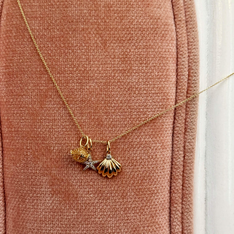 Still life image of Soft Inside Pufferfish Charm with Stone and Strand solid gold jewelry
