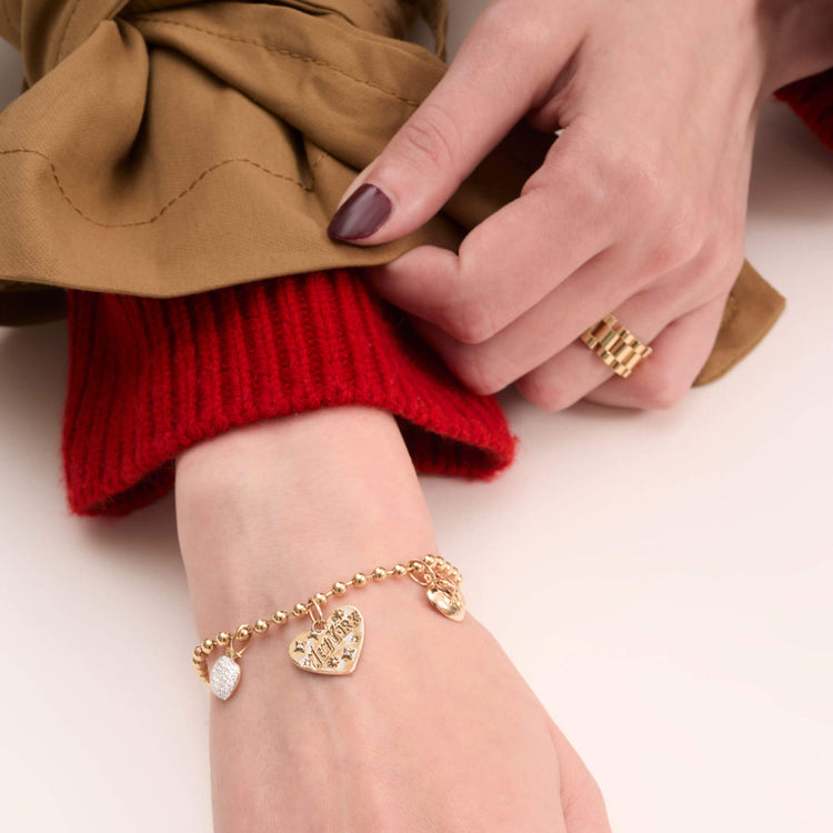 Model wearing The Pave Big Apple Charm with solid gold Stone and Strand jewelry