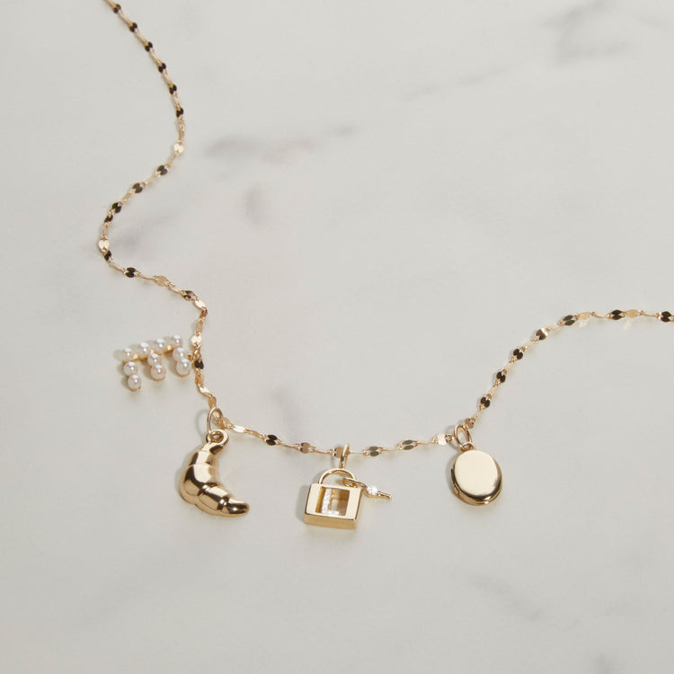 Still life image of Pearly Initial Necklace with Stone and Strand solid gold jewelry