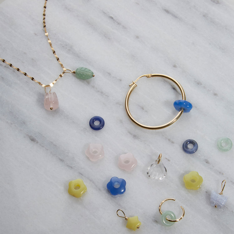 Still life image of Lucky Star Charm with Stone and Strand solid gold jewelry