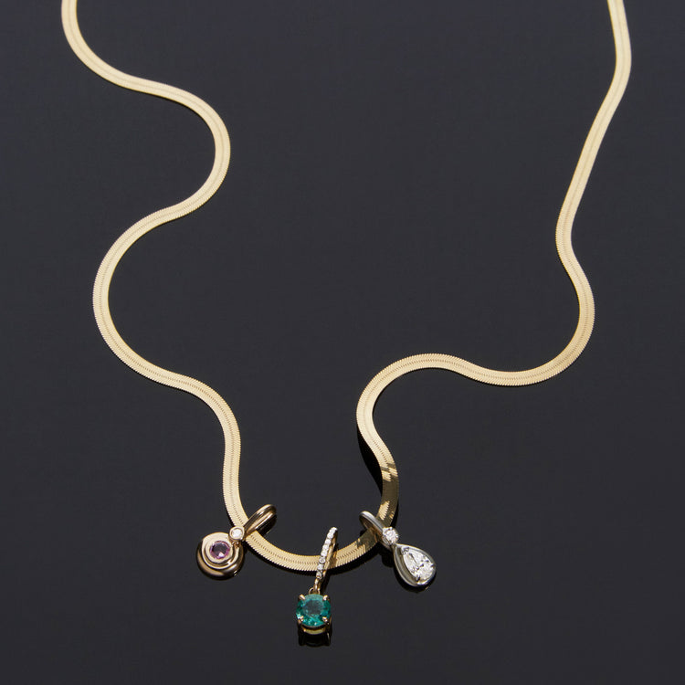 Still life image of Sparkling Emerald Luxe Charm with Stone and Strand solid gold jewelry