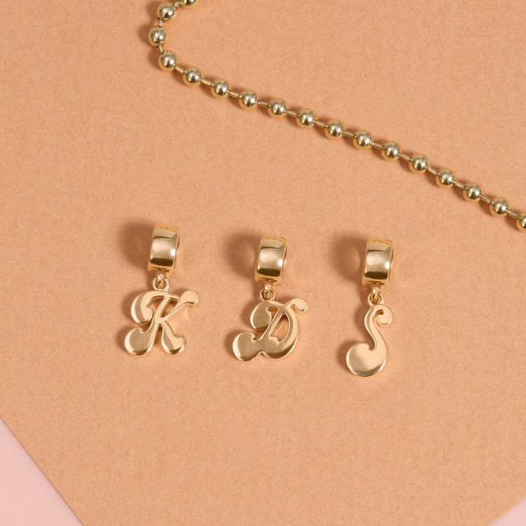 Still life image of Woodstock Initial Charm with Stone and Strand solid gold jewelry