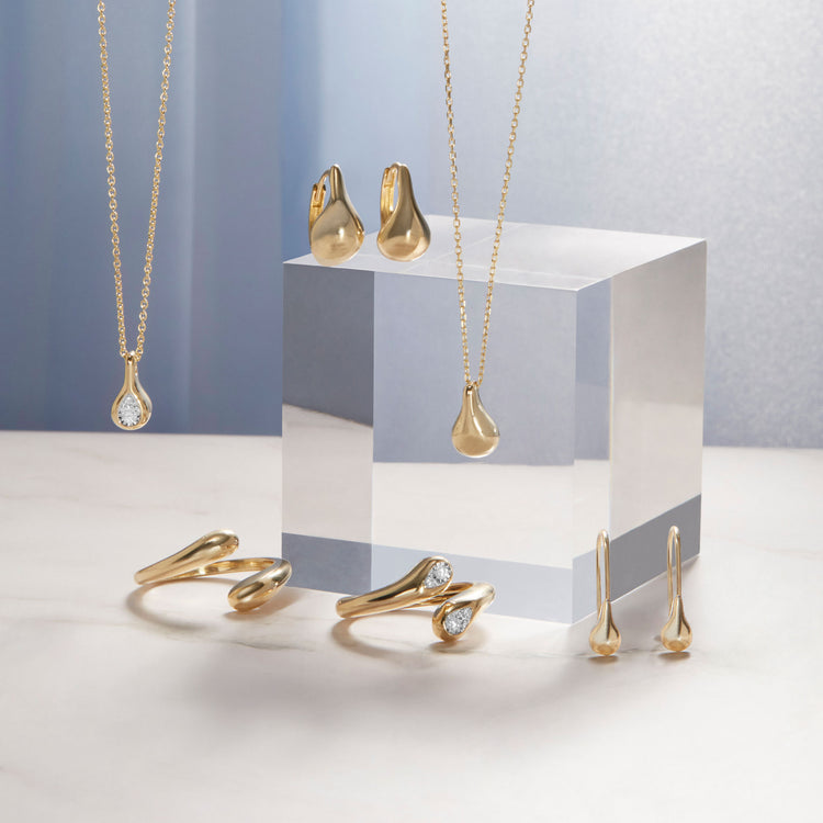 Still life image of Golden Droplet Huggies with Stone and Strand solid gold jewelry