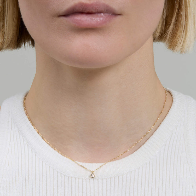 Image of 14K Yellow Gold The Essential Dainty Diamond Solitaire Necklace on Models Neck