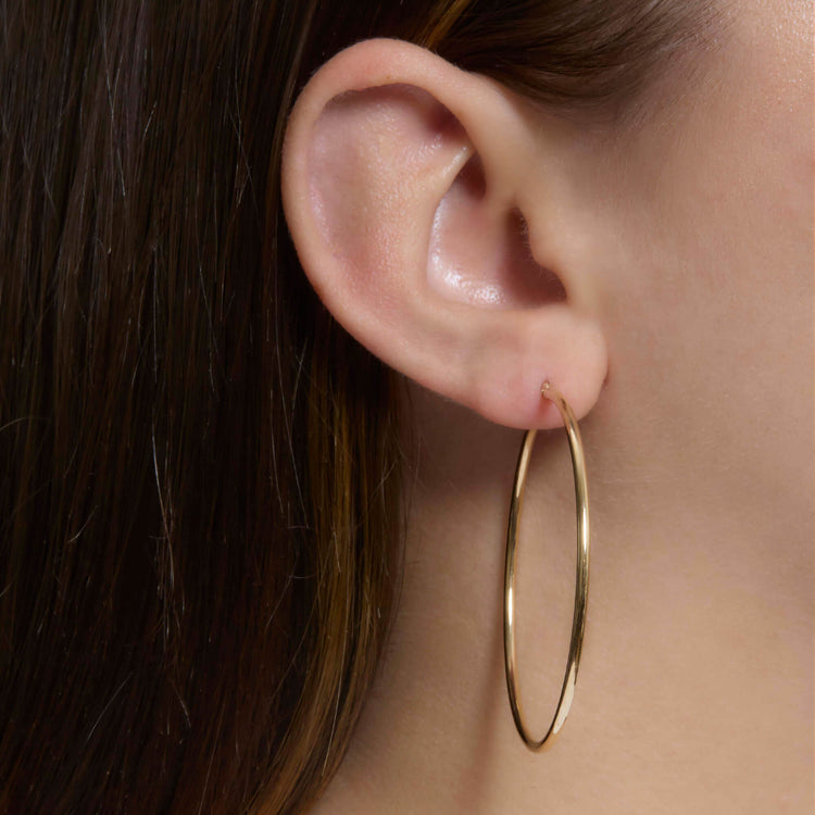 Image of 14K Yellow Gold Thin Gold Hoops 50mm on Models Ear