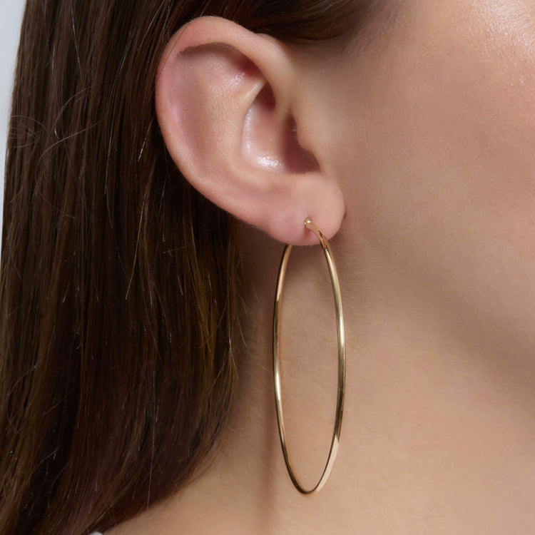 Image of 14K Yellow Gold Thin Gold Hoops 65mm on Models Ear