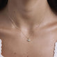 Image of 10K Yellow Gold Tiny Evil Eye Diamond Necklace on Models Neck