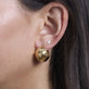 Model wearing Ultra Puff Gold Huggies with solid gold Stone and Strand jewelry