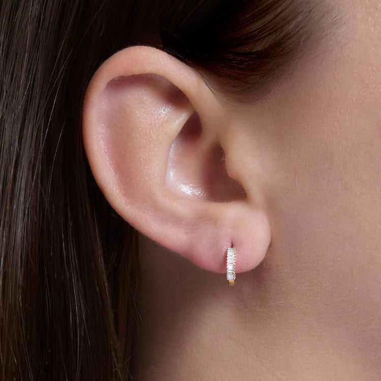 Image of 10K Yellow Gold Dainty Up And Down Baguette Diamond Huggies on Models Ear