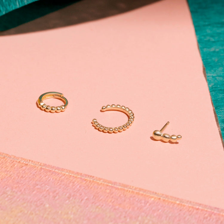 Still life image of Tiny Beaded Huggies with Stone and Strand solid gold jewelry
