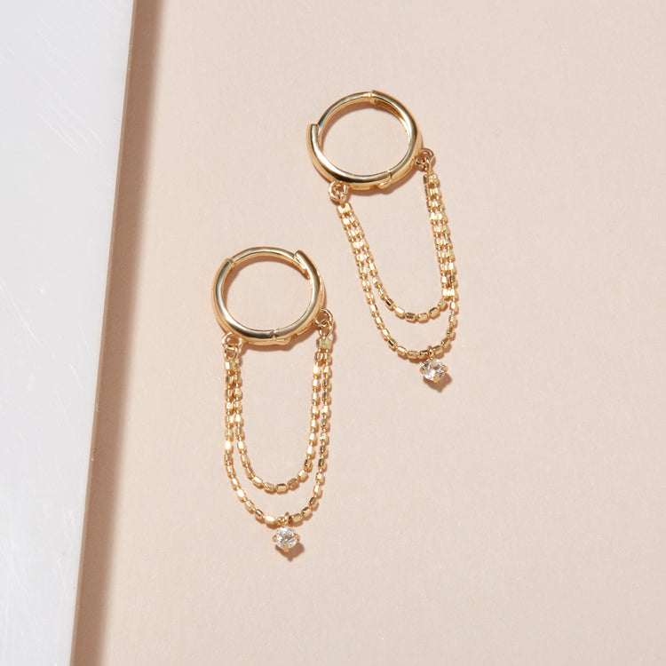 Stone and Strand 14K Yellow Gold Chain Reaction Topaz Huggies Editorial Image