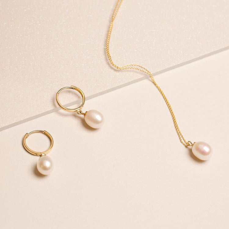 Still life image of Elliptical Pearl Huggies with Stone and Strand solid gold jewelry