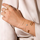 Model wearing Flat Cuff Bracelet with solid gold Stone and Strand jewelry
