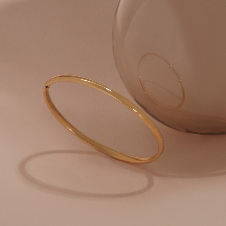 Still life image of Golden Classic Bangle with Stone and Strand solid gold jewelry