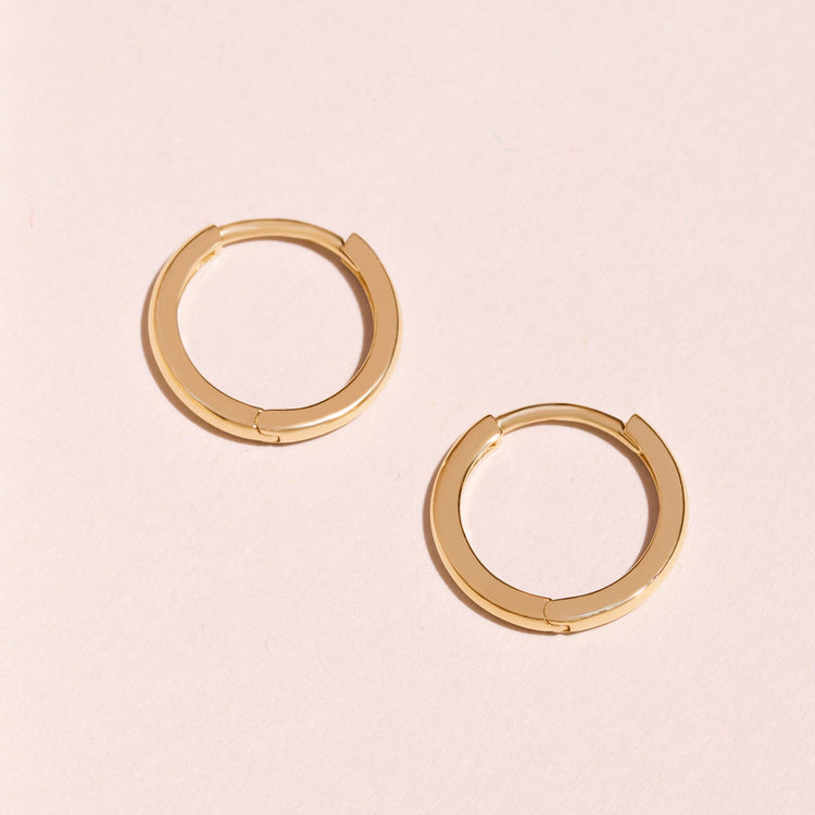 Stone and Strand 14K Yellow Gold Dainty Small Gold Huggie Clicker Earring Editorial Image
